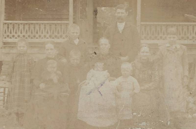 This photo is a "close-up" of the family shown in hte above photo. I "believe" the people are (from left to right): \\
Gertrude Randall (age 8) \\
Sallie D. Randall-Mitchell (Henry Oran Randall's sister - age 26) holding her daughter, Flora R. Mitchell (born Feb. 1894) \\
King Oran Randall (age 11) - Back row. \\
Clarence Randall (age 4 1/2) - standing in front of King Oran. \\
Julia Ann Sewell-Randall holding Charlie David Randall (b. July 27, 1894 – May 17, 1895. Died in infancy – at 9 months old). His death is indicated by the "X" over him. \\
Henry Oran Randall \\
Jones Marshall Randall (age 2 1/2) \\
Sallie Mitchell-Randall (Henry Oran's mother) \\
Lavaca Randall (between 9 1/2 years old)
