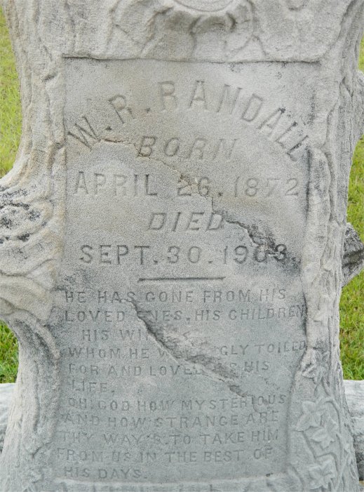 Tombstone inscribed: "W. R. Randall. Born April 26, 1872. Died Sept. 30, 1903". Below this inscription is a standard inscription from Woodsmen of the World: "He has gone from his loved ones, his children, his wife. Whom he willingly toiled for and loved as his life. Oh God how mysterious and how strange are thy ways to take him from us in the best of his days."