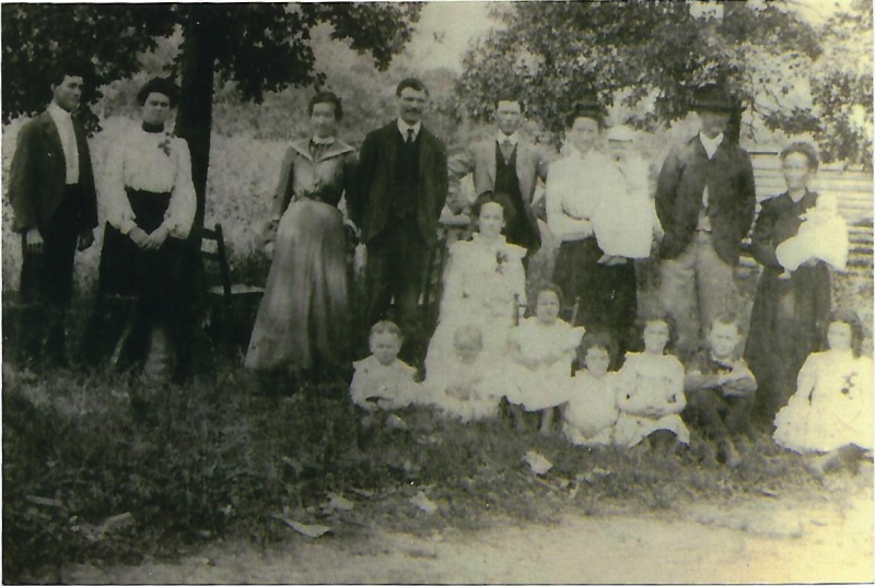 Thomas Watson Randall (back row, 2nd from right) and Rutha Ella Farmer (back row, furthest right) family photo. Other family members not yet identified. Year unknown.